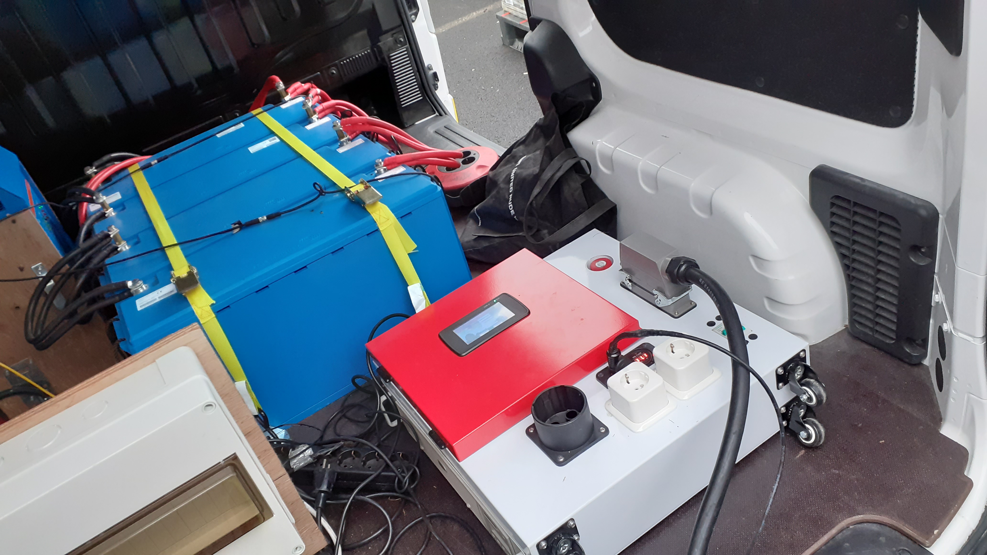 Electric van connected (left photo) to AIRQON charger combined with batteries (right photo)